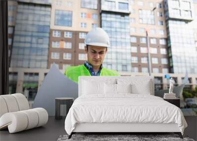 portrait of handsome young man with blueprint architect on a building industry construction site Wall mural